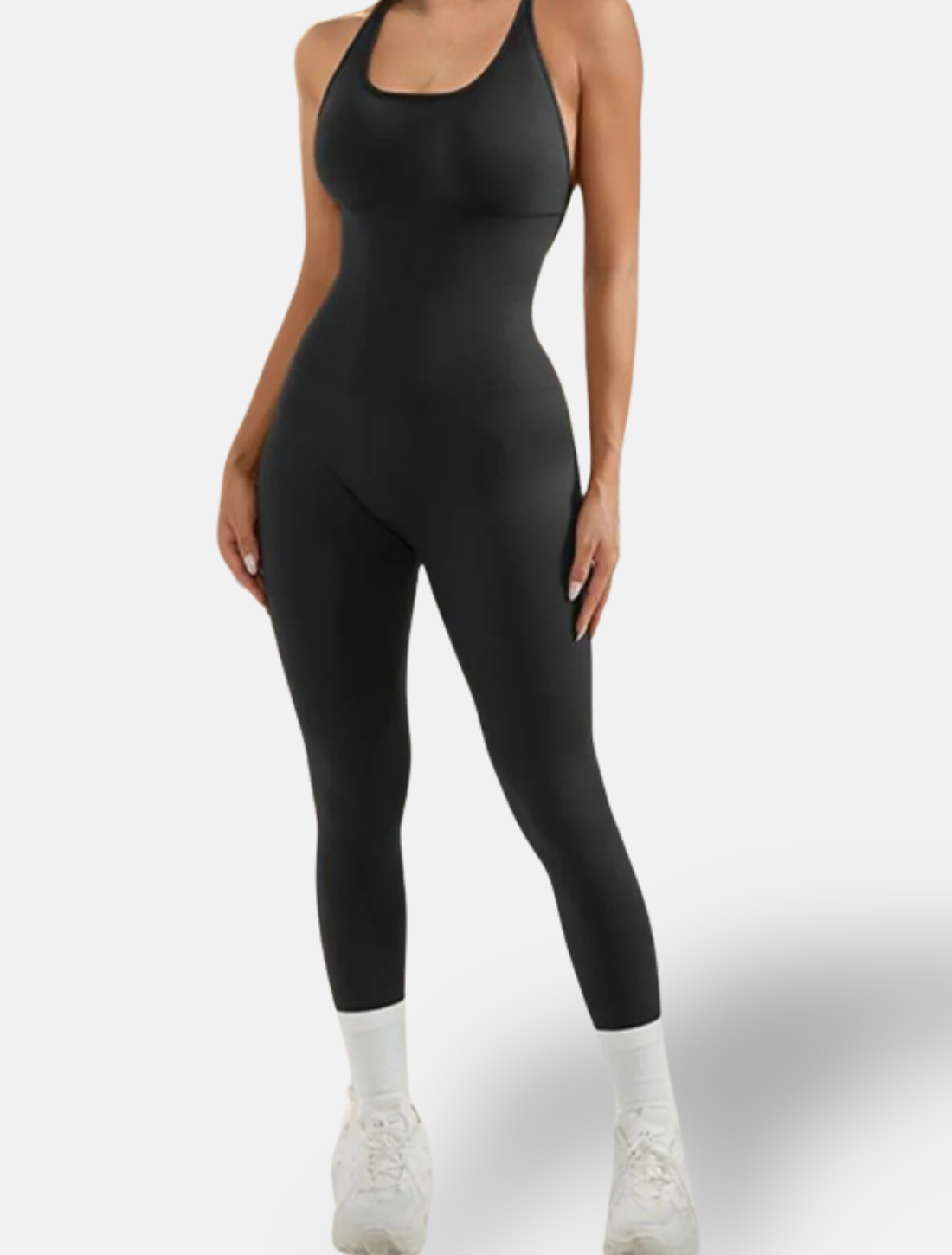 Mulher usando um macacão fitness preto com alças finas e corte ajustado ao corpo. Design minimalista, ideal para treinos, com conforto e liberdade de movimento.